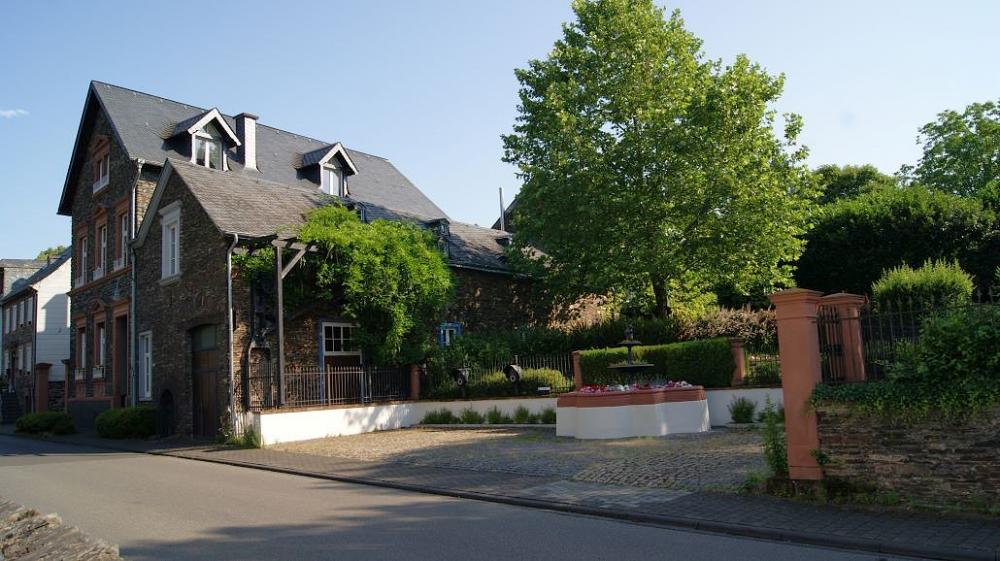 Haupthaus mit Nebengebäude und Parkplatz